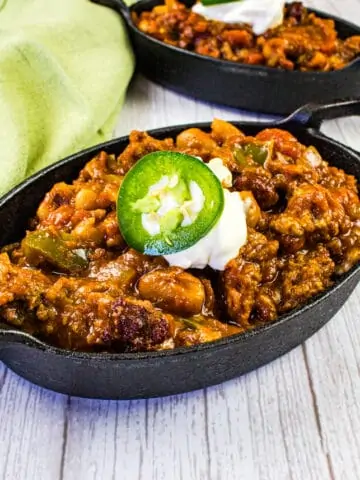 Over the top chili in black cast iron pans