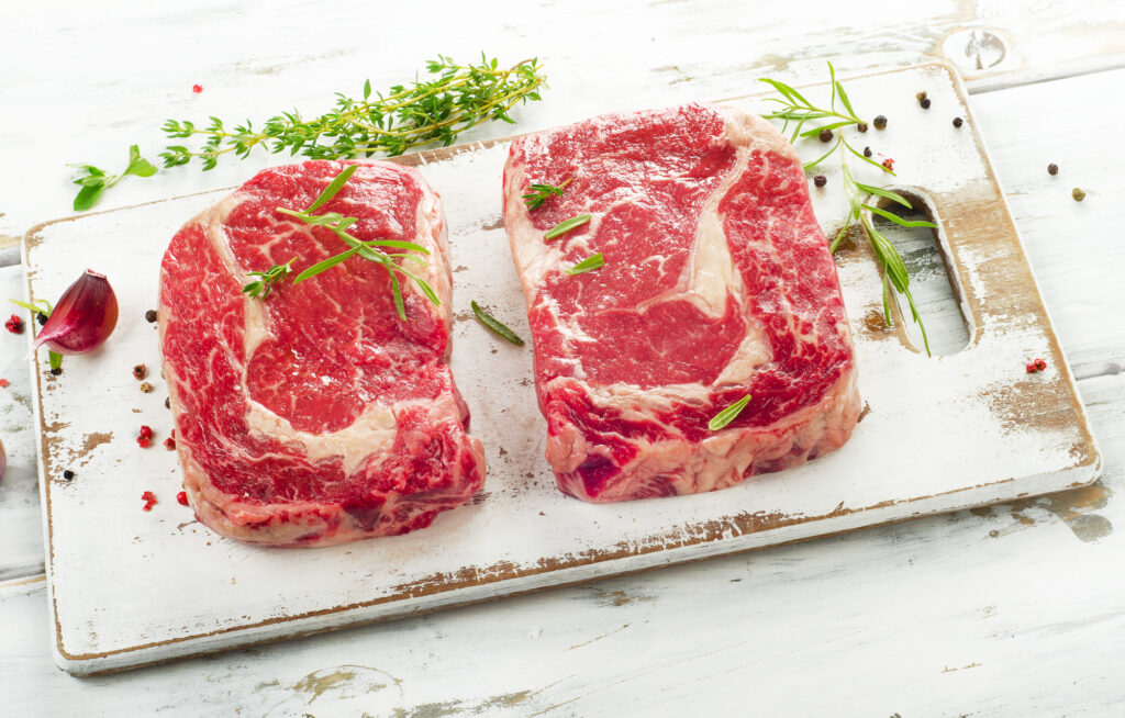 ribeye steaks on cutting board