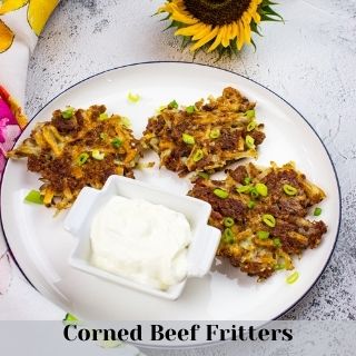 corned beef fritters on a plate with sour cream.