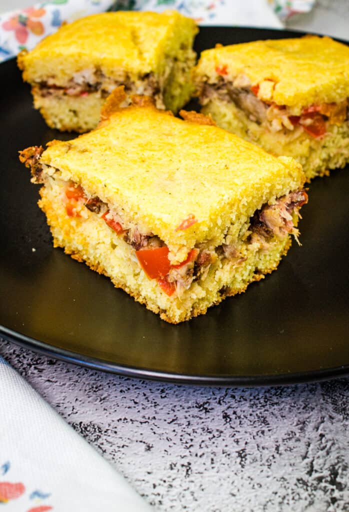 pulled pork stuffed cornbread on a black plate