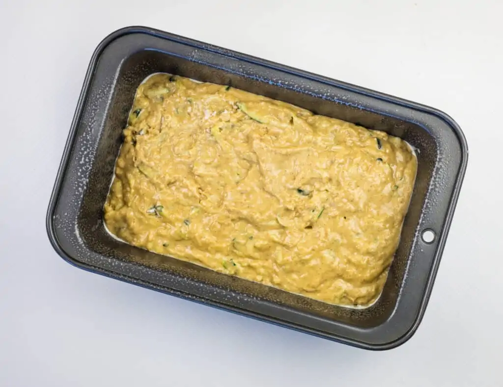 add zucchini bread batter to a loaf pan and bake