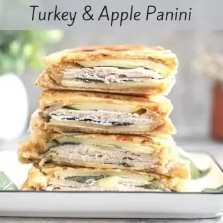 A stacked turkey and apple panini sandwich.