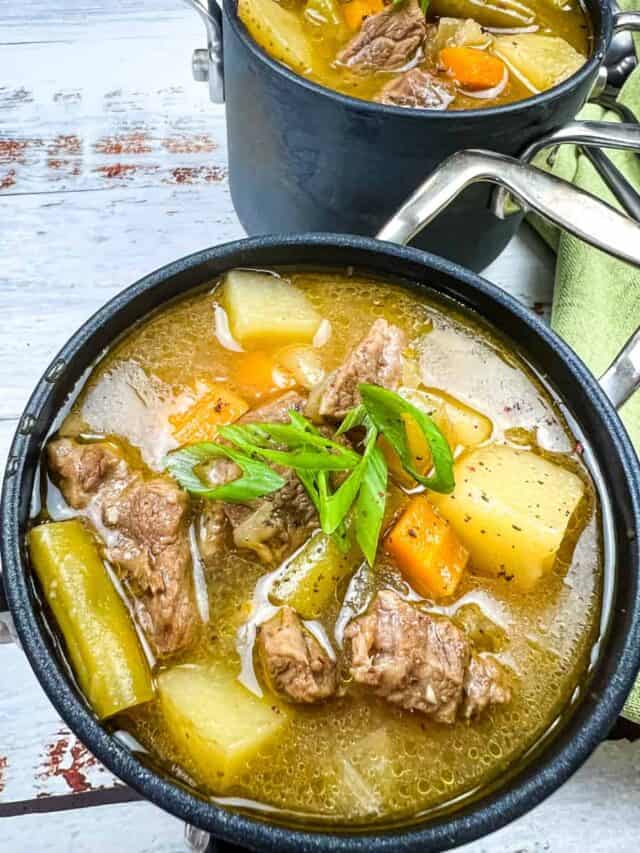 Steak & potato soup in a small black bowl