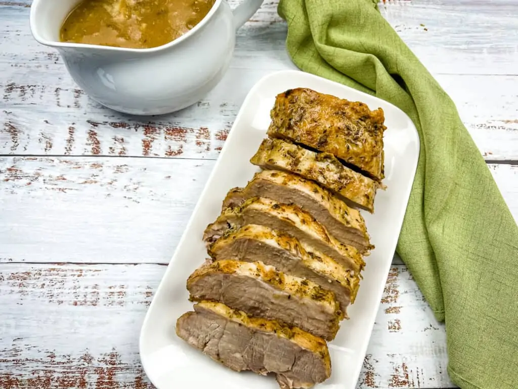 German Pork loin on a plate with gravy to the side.