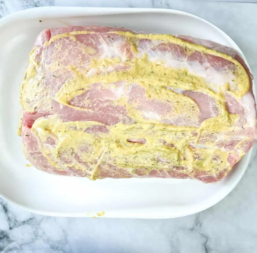 coating the pork with mustard