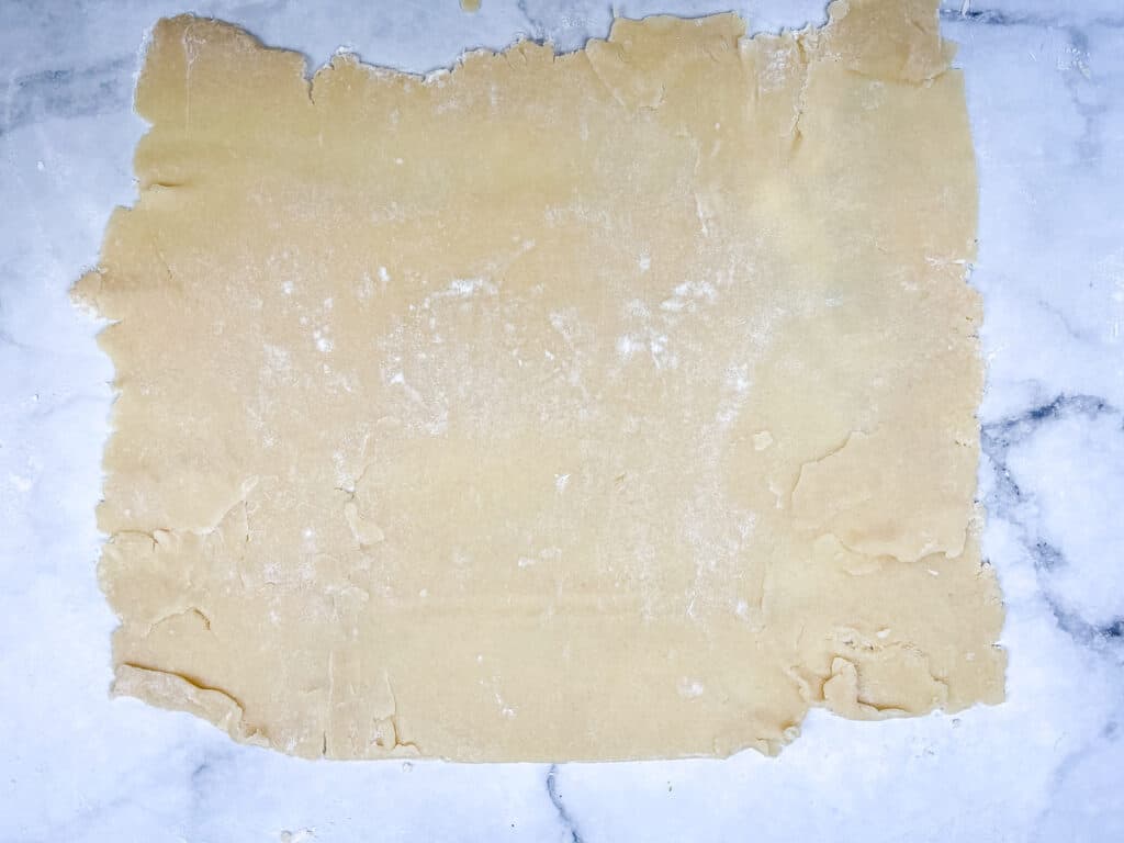 a rectangle of rolled cinnamon roll cookie dough