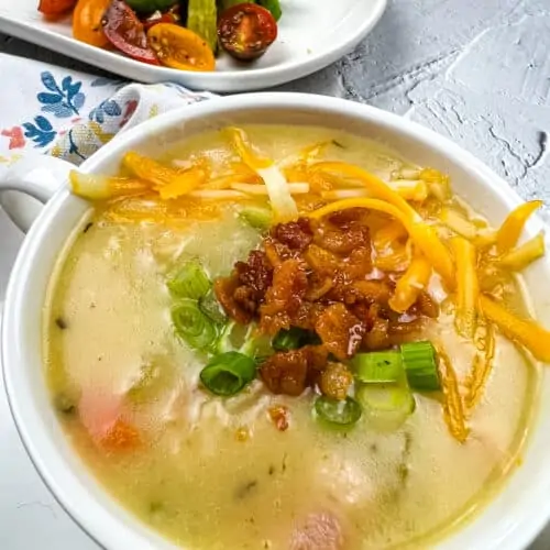 Fully loaded baked potato soup in a white bowl.