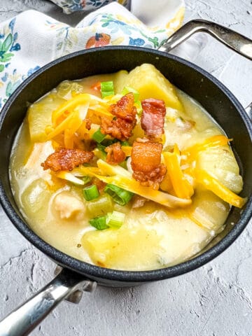 fully loaded baked potato soup in a black bowl