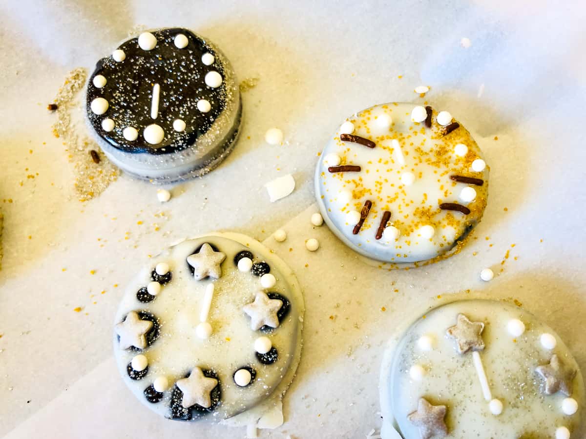 A group of cookies decorated with icing and different shapes of candy sprinkles.