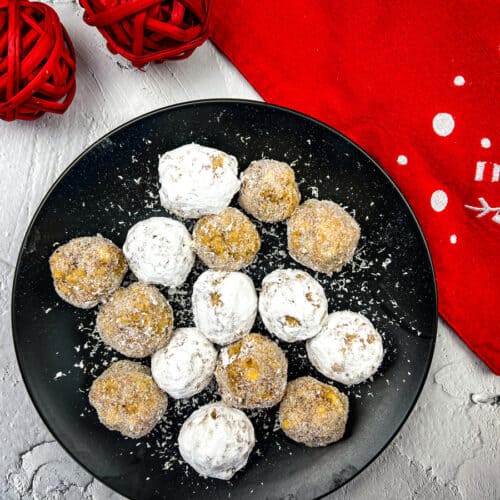 Bourbon white chocolate snowballs on a black plate.