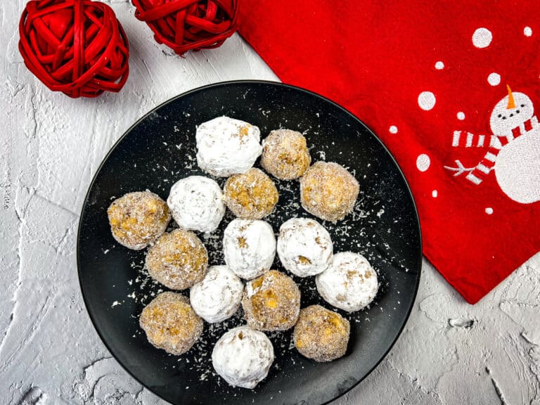 Bourbon white chocolate snowballs on a black plate.