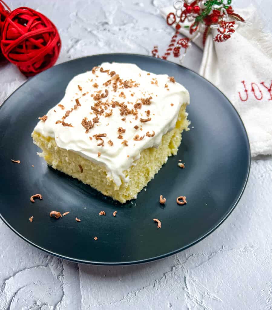 eggnog tres leches cake slice on a black plate