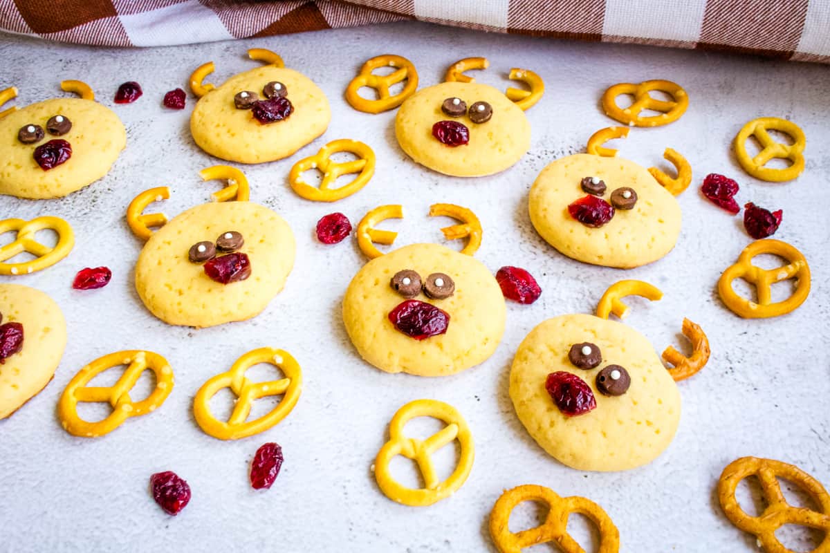 Peanut butter cookies with a face made of pretzels and dried cranberries to look like a reindeer.