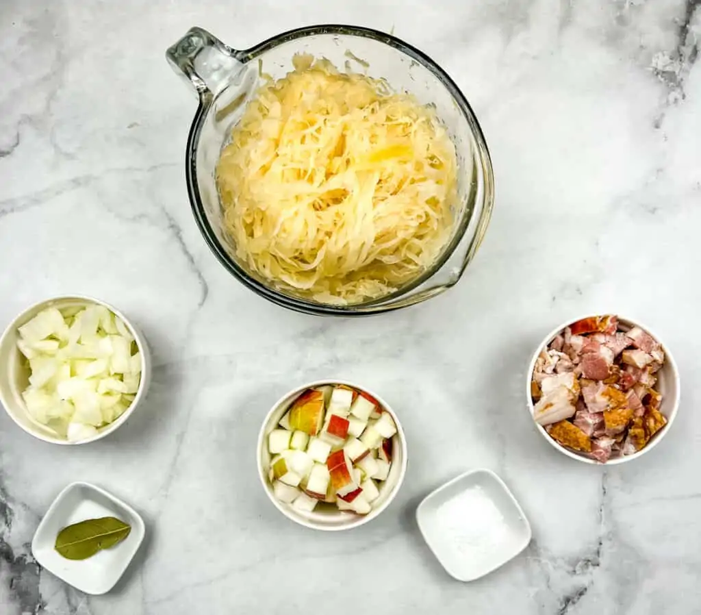Ingredients to make sauerkraut with bacon and apple.