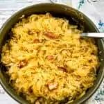 oven baked sauerkraut with bacon and apples in a serving dish