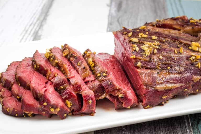 A smoked beef tenderloin on a white plate.