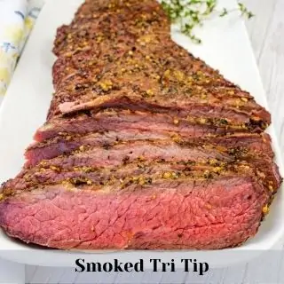 Sliced Smoked Tri Tip on a white platter.