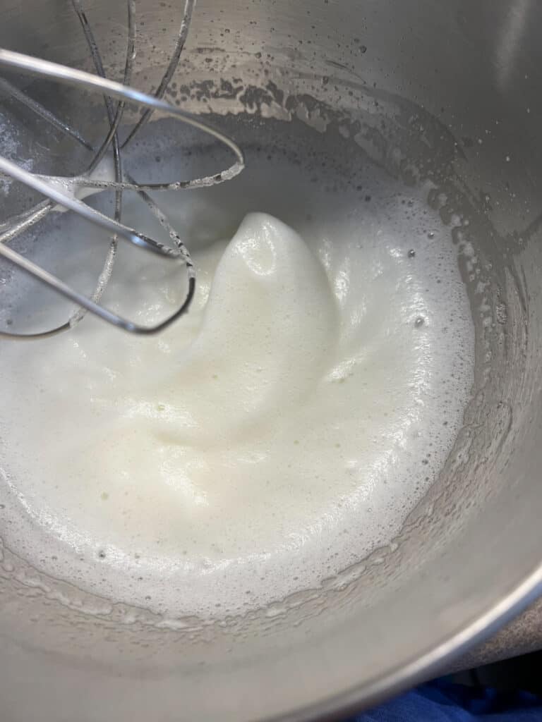 Whipped egg whites and sugar in a bowl.