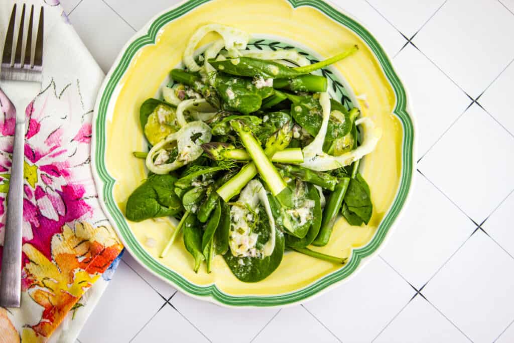 spinach, asparagus, & fennel salad on a yellow plate