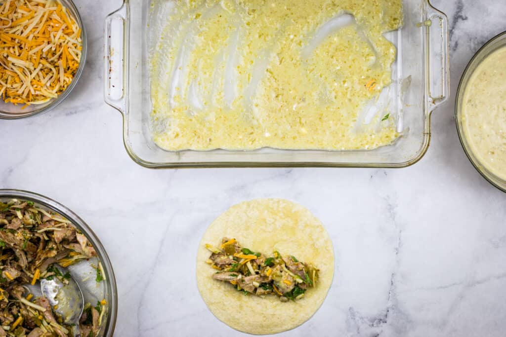 Filling and rolling chicken enchiladas.