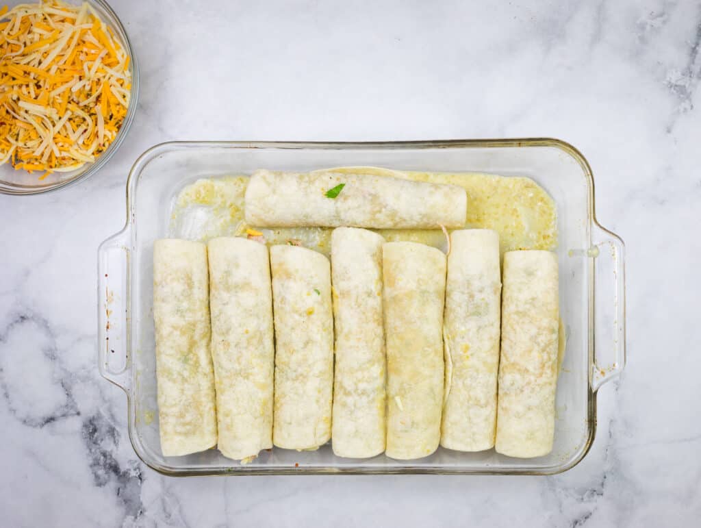 Rolled tortillas in a baking dish.