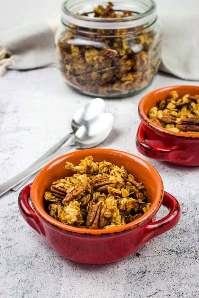 maple pecan granola in two bowls with spoons