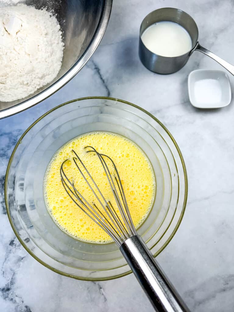 Whisking the eggs and milk to make easy spaetzle recipe