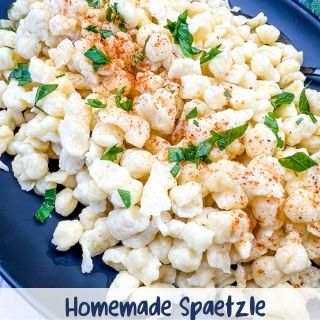 Homemade spaetzle on a black plate.
