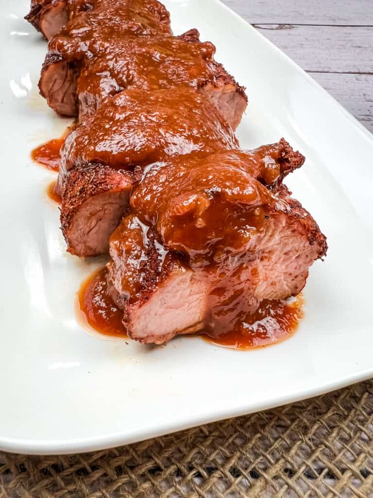 chipotle bourbon bbq sauce on pork tenderloin on a plate