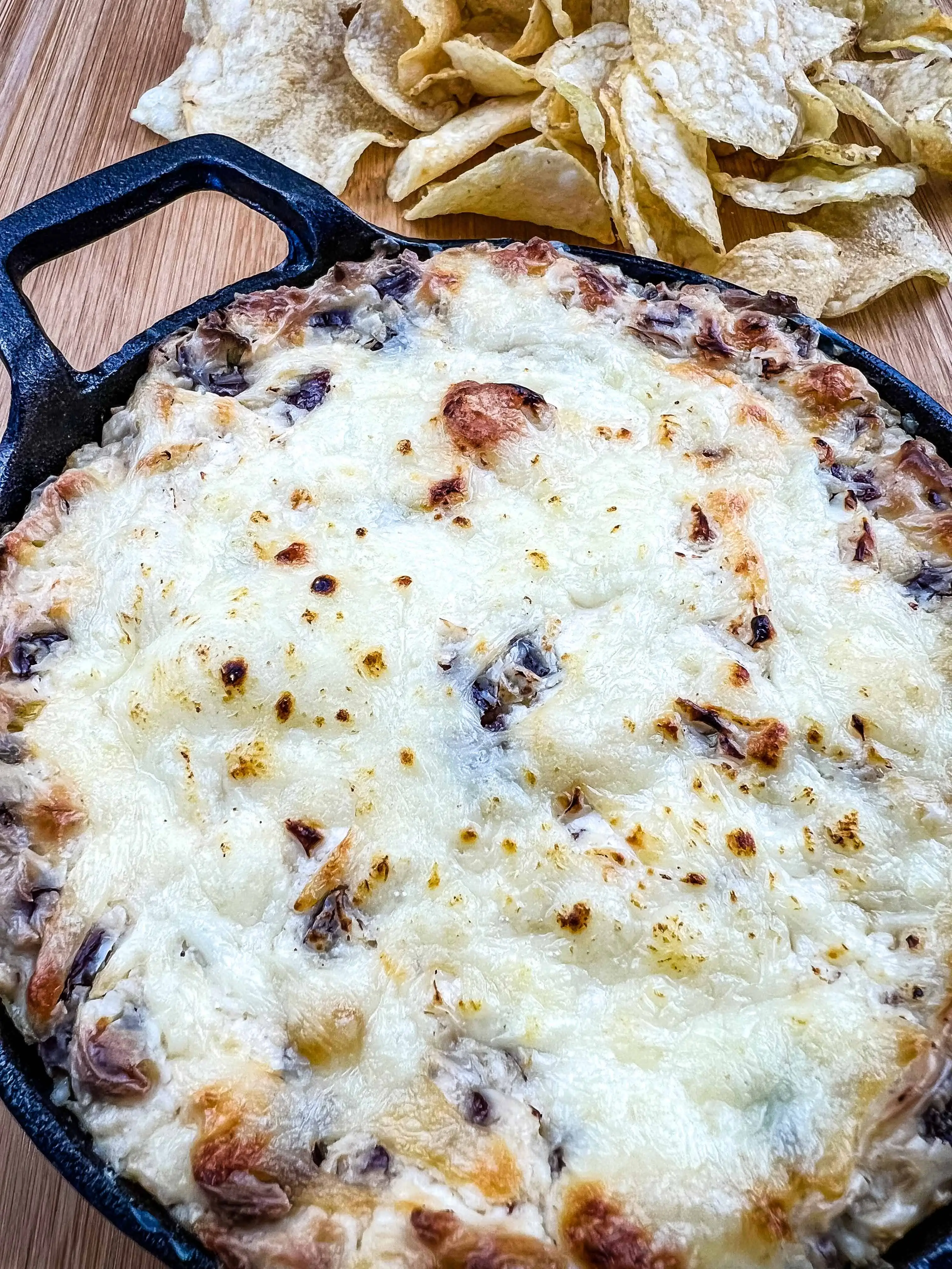 beef jerky dip in a black baking dish with potato chips in background