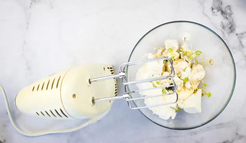 mixing the cream cheese, sour cream, green onions and worcestershire sauce in a bowl