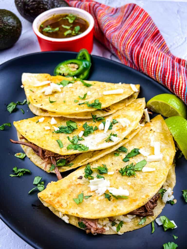 birria tacos on a black plate