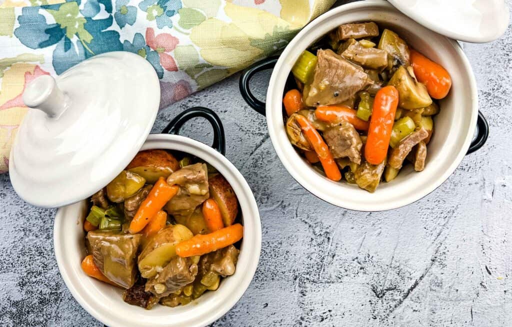 overhead shot of leftover roast beef stew in two bowls with lids