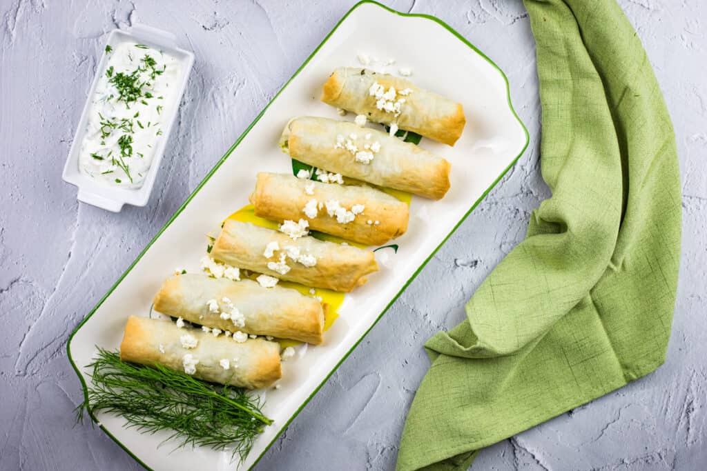 a top-down shot of spanakopita rolls on a plate.
