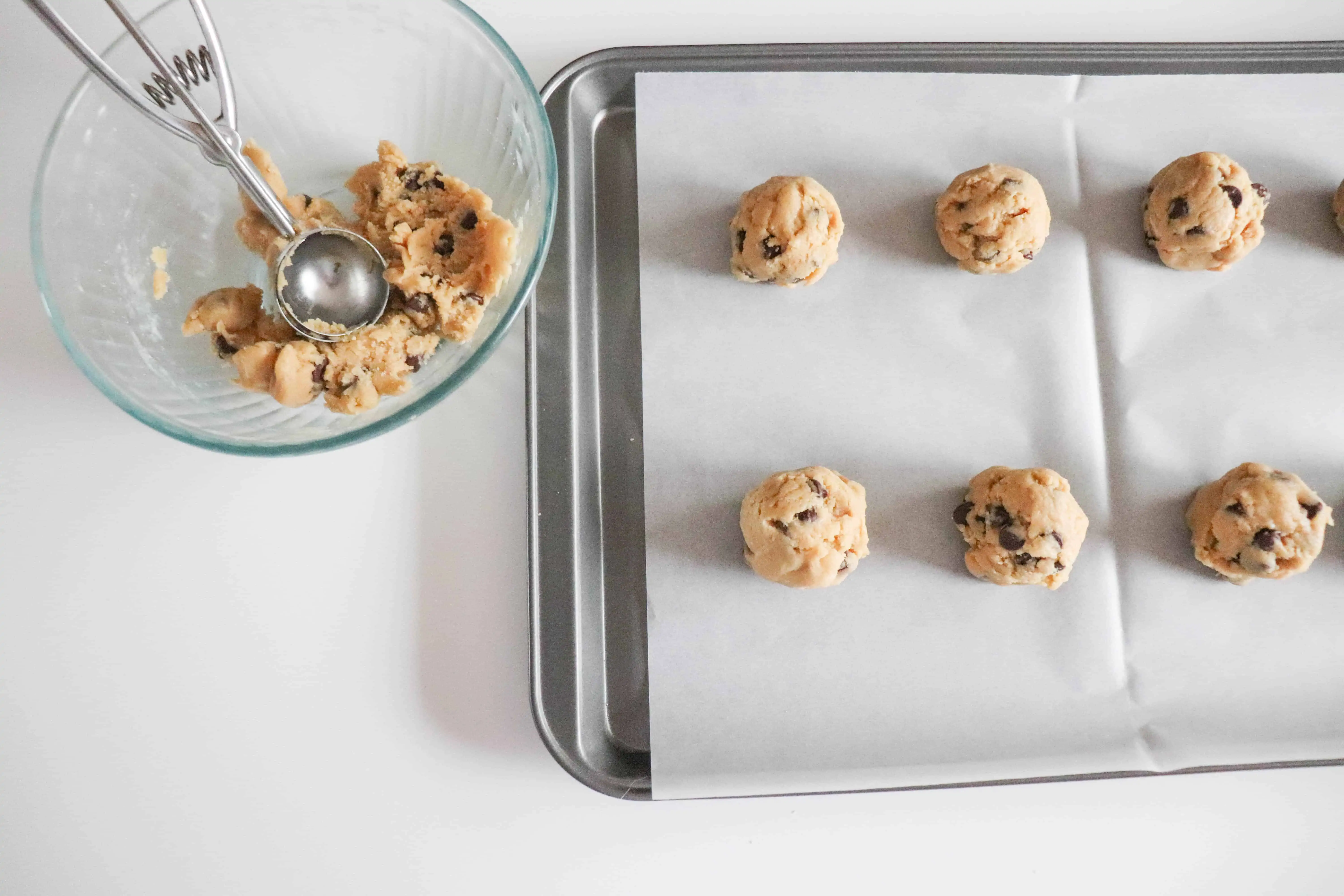scooped cookie batter on a baking sheet