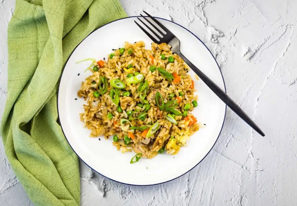 chicken fried rice made on the blackstone griddle on a white plate