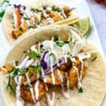 baja fish tacos with cod on a white plate