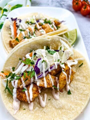baja fish tacos with cod on a white plate