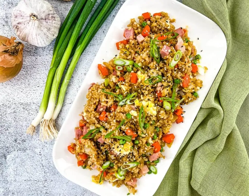 Ham fried rice on a white plate.