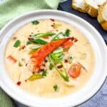lobster chowder in a bowl with bread in background