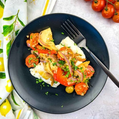 Mediterranean cod served on a black plate.