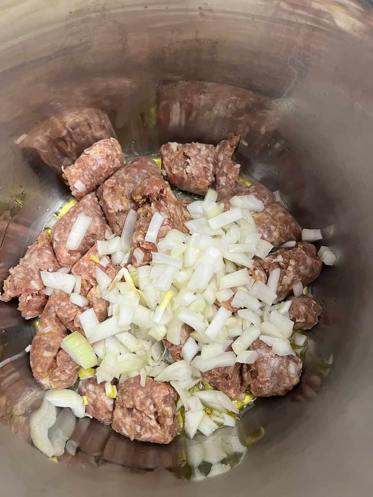 cooking the sausage and onions in the Instant Pot insert