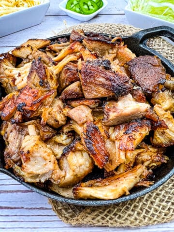 dutch oven carnitas in a cast iron serving dish