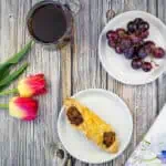 cheese and bacon turnovers on a plate with flowers and coffee in the background