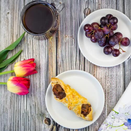 cheese and bacon turnovers on a plate with flowers and coffee in the background