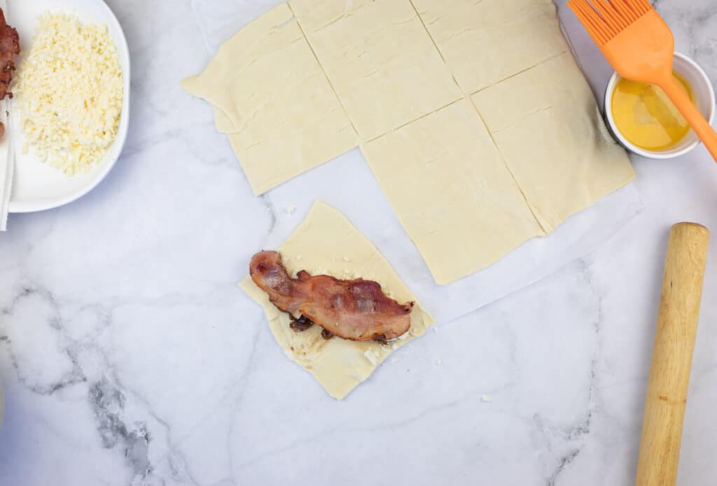filling the pastry with onion jam, cheese, and bacon