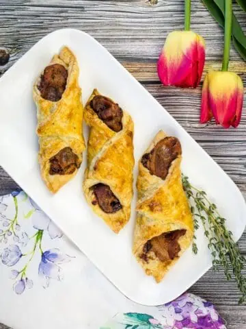 cheese and bacon turnovers on a plate with flowers in the background