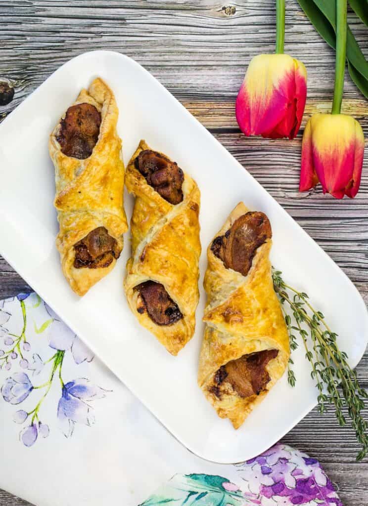 cheese and bacon turnovers on a plate with flowers in the background