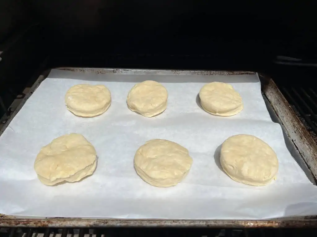 cut biscuits on a parchment paper lined baking sheet in the smoker.