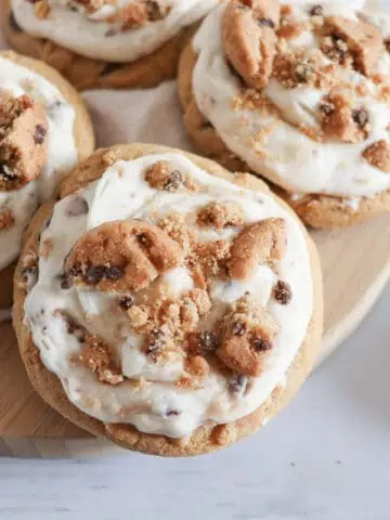 cookie frosted chocolate chip cookies on a board